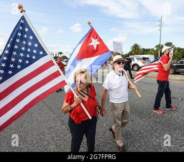 Orlando, Usa. Juli 2021. Demonstranten marschieren mit amerikanischen und kubanischen Flaggen auf der Straße, während sie in Orlando zur Unterstützung des kubanischen Volkes und gegen die kubanische Regierung demonstrieren, nachdem Tausende von Kubanern auf die Straßen im ganzen Land gingen, um gegen Stromausfälle, Pandemiebeschränkungen und das Tempo der Covid-19-Impfungen zu protestieren. (Foto von Paul Hennessy/SOPA Images/Sipa USA) Quelle: SIPA USA/Alamy Live News Stockfoto