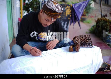 Pasuruan, Indonesien. Juni 2021. Nahaufnahme eines Mannes, der Batik typisch für den Stamm der Bromo Tengger macht. Junge Künstler, die Ethnizität und Kultur in bewahren Stockfoto