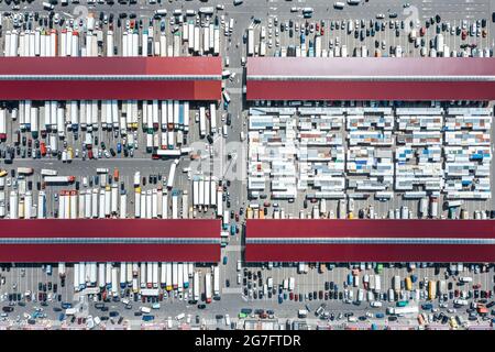 Großhandelsmarkt für Landwirte. Viele Lastwagen an Lagerhäusern. Vogelaugen. Stockfoto
