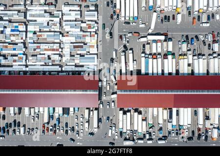 Luftaufnahme des Großhandelsmarktes für Landwirte. Viele Anhänger-Lastwagen an Lagerdocks. Stockfoto