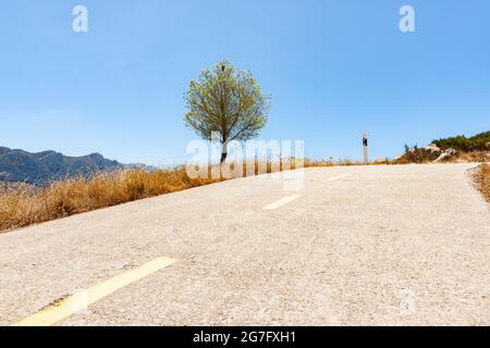 Straße durch Coll de Rates Informationen zum Aufstieg Straße, die sich durch die Berge schlängelt und zum Felsvorsprung am Gipfel führt, vorbei an uralten Steinterrassen auf der Co Stockfoto