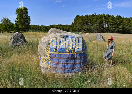 13. Juli 2021, Brandenburg, Henzendorf: Dorothee Schmidt-Breitung, Restauratorin, steht auf dem Gelände des erratischen Blockparks Henzendorf. Diese Zeichnungen wurden im vergangenen Jahr restauriert. Der erratische Blockpark mit seinen rund 100 behauenen und bemalten erratischen Blöcken entstand 1997. Seit mehr als 20 Jahren wachsen Moos und Flechten auf den Steinen und die Farben verblassen allmählich. Im Jahr 2020 wurden 18 Steine restauriert. Derzeit werden unter der Leitung von Restauratorin Dorothee Schmidt-Breitung weitere 24 Steine von biogenem Wachstum gereinigt und die Farben erneuert. Die Arbeit wird von d finanziert Stockfoto