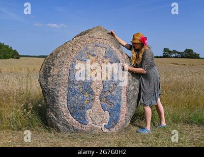 13. Juli 2021, Brandenburg, Henzendorf: Dorothee Schmidt-Breitung, Restauratorin, reinigt die geschnitzten und bemalten Figuren und Figuren auf einem Felsbrocken auf dem Gelände des Henzendorfer Boulderparks. Der erratische Blockpark mit seinen rund 100 behauenen und bemalten erratischen Blöcken entstand 1997. Moos und Flechten wachsen seit über 20 Jahren auf den Steinen und die Farben verblassen allmählich. Im Jahr 2020 wurden 18 Steine restauriert. Derzeit werden unter der Leitung von Restauratorin Dorothee Schmidt-Breitung weitere 24 Steine von biogenem Wachstum gereinigt und die Farben erneuert. Die Arbeit ist Finanzierung Stockfoto