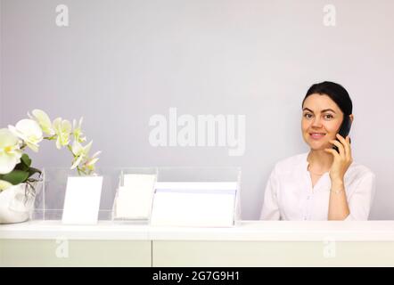 Brünette Frau Rezeptionistin arbeitet im Krankenhaus Stockfoto