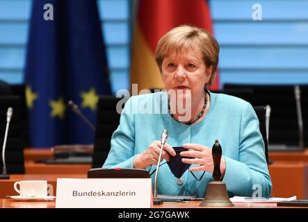 Berlin, Deutschland. Juli 2021. Bundeskanzlerin Angela Merkel (CDU) zieht zu Beginn der Kabinettssitzung im Kanzleramt ihre Maske aus. Kredit: Annegret Hilse/Reuters/Pool/dpa/Alamy Live Nachrichten Stockfoto