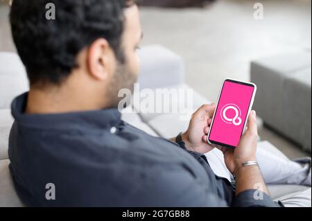 Kiew, Ukraine - 28. April 2021: Smartphone in männlichen Händen mit Google Fuchsia OS auf dem Bildschirm, indischer freiberuflicher Mitarbeiter mit neuem OS auf seinem Handy Stockfoto