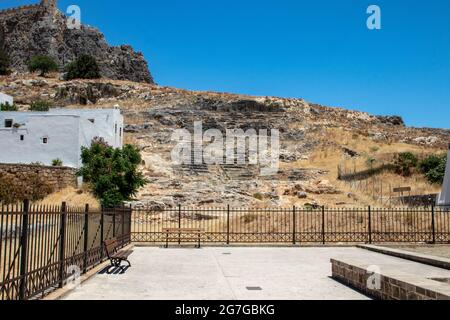 LINDOS, Griechenland - 05. JUNI 2021. Ein Theater, das aus Felsen geschnitzt wurde, wurde am Südhang der Akropolis aufgedeckt. Es ist auf das 4. Jahrhundert datiert Stockfoto