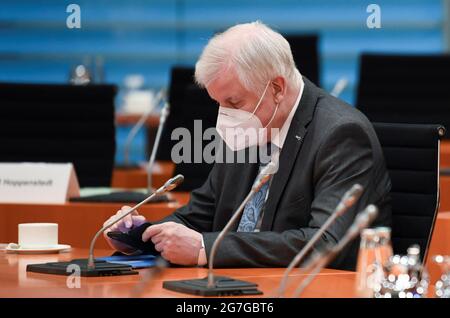 Berlin, Deutschland. Juli 2021. Bundesinnenminister Horst Seehofer (CSU) sitzt bei einer Kabinettssitzung in einer Maske im Kanzleramt und blickt auf sein Smartphone. Kredit: Annegret Hilse/Reuters/Pool/dpa/Alamy Live Nachrichten Stockfoto