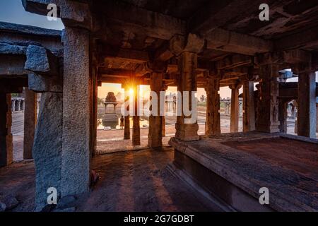 Blick auf Sonnenaufgang in Pushkarni, Sri Krishna Tank in Ruinen. südseite des Pools mit Schrein. Felsbrocken und Berge am Horizont. Hampi, Karnataka, Indien. Stockfoto