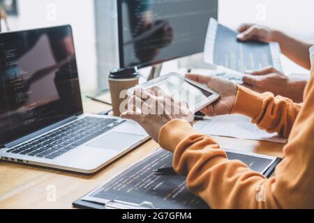 Schreiben von Codes und Eingabe von Datencode-Technologie, Programmierer kooperiert bei der Arbeit an Website-Projekt in einer Software, die auf Desktop-Computer bei comp Stockfoto