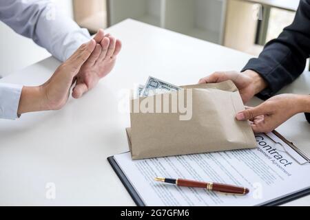 Bestechung und Korruption Konzept, Geschäftsmann weigert sich, Geld in den Umschlag zu Vertrag, EINE Bestechung in Form von Dollarscheinen erhalten. Stockfoto