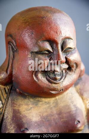 Traditionelle Holzstatue des chinesischen Buddha isoliert auf dunklem Hintergrund Stockfoto