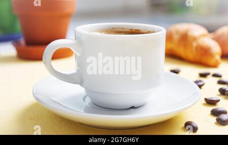 Tasse Kaffee, frische Croissants auf dem Tisch. Traditionelles Frühstück. Guten Morgen. Stockfoto