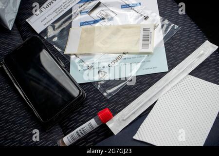 Covid-19 pcr-Testkit auf dem Beifahrersitz eines Autos bei einer Fahrt durch das Testzentrum Stockfoto