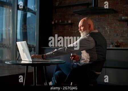Männlicher Freiberufler arbeitet nachts auf einem Laptop. Stockfoto