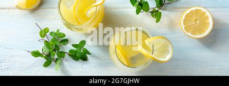 Limonadenpanorama. Hausgemachtes frisches Getränk mit Zitrone und Eis, von oben auf einem Holzhintergrund geschossen. Gesundes Bio-Sommergetränk Stockfoto