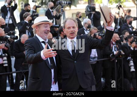 Cannes, Frankreich. Juli 2021. Der Schauspieler Denis Podalydes (l.) und der Regisseur Arnaud Desplechin nehmen an der Vorführung des Films „Aline – die Stimme der Liebe“ während der 74. Jährlichen Filmfestspiele von Cannes im Palais des Festivals Teil. Quelle: Stefanie Rex/dpa-Zentralbild/dpa/Alamy Live News Stockfoto