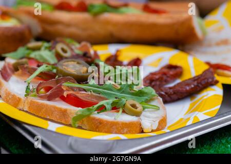 Sandwich mit Rucola, Schinken, Käse, Jalapeno, getrockneten Tomaten - Nahaufnahme Stockfoto