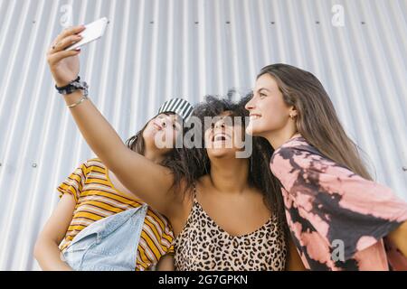 Drei schöne junge Frauen verschiedener Rassen mit ihren langen Brettern Stockfoto