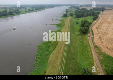 GESPEICHERT - 14. Juli 2021, Sachsen-Anhalt, Sandau: Blick auf den alten Deich Sandau-Süd an der Elbe (Luftaufnahme mit Drohne). Hier fand am Mittwoch der Spatenstich für das Deichschneiden statt. Die vergangenen Hochwasserereignisse in den Jahren 2002 und 2013 zeigten, dass der bestehende Deich zwischen Sandau und Havelberg dringend renoviert werden muss. Die Deichumsiedlung ist Teil des Nationalen Hochwasserschutzprogramms der Bundesrepublik Deutschland und des Programms "Mehr Raum für unsere Flüsse" in Sachsen-Anhalt. Durch den Umzug werden hier rund 124 Hektar Auen zurückgewinnen, verglichen mit etwa 60 Hektar Stockfoto