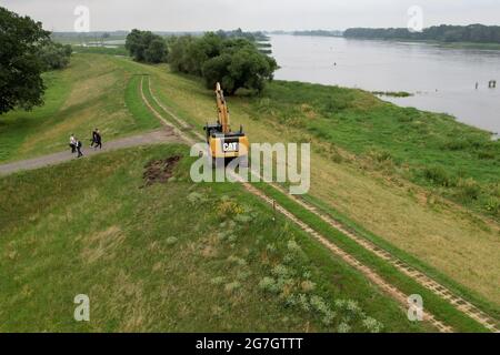 GESPEICHERT - 14. Juli 2021, Sachsen-Anhalt, Sandau: Blick auf den alten Deich Sandau-Süd an der Elbe (Luftaufnahme mit Drohne). Hier fand am Mittwoch der Spatenstich für das Deichschneiden statt. Die vergangenen Hochwasserereignisse in den Jahren 2002 und 2013 zeigten, dass der bestehende Deich zwischen Sandau und Havelberg dringend renoviert werden muss. Die Deichumsiedlung ist Teil des Nationalen Hochwasserschutzprogramms der Bundesrepublik Deutschland und des Programms "Mehr Raum für unsere Flüsse" in Sachsen-Anhalt. Durch den Umzug werden hier rund 124 Hektar Auen zurückgewinnen, verglichen mit etwa 60 Hektar Stockfoto