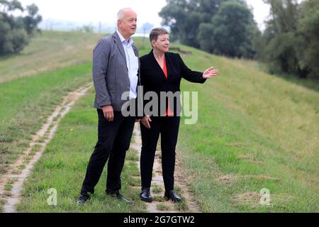 EINGEREICHT am 14. Juli 2021, Sachsen-Anhalt, Sandau: Umweltministerin Claudia Dalbert (Bündnis 90/die Grünen, r) und der Direktor der Landesagentur für Hochwasserschutz und Wasserwirtschaft, Burkhard Henning, stehen vor dem Spatenstich für die Deichschneidung auf dem alten Deich Sandau-Süd. Die vergangenen Hochwasserereignisse in den Jahren 2002 und 2013 zeigten, dass der bestehende Deich zwischen Sandau und Havelberg dringend saniert werden muss. Die Deichumsiedlung ist Teil des Nationalen Hochwasserschutzprogramms der Bundesrepublik Deutschland und des Programms "Mehr Raum für unsere Flüsse" in Sachsen-Anh Stockfoto