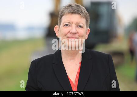 EINGEREICHT - 14. Juli 2021, Sachsen-Anhalt, Sandau: Umweltministerin Claudia Dalbert (Bündnis 90/die Grünen) steht vor dem Spatenstich für die Deichschneidung auf dem alten Deich Sandau-Süd. Die vergangenen Hochwasserereignisse in den Jahren 2002 und 2013 zeigten, dass der bestehende Deich zwischen Sandau und Havelberg dringend renoviert werden muss. Die Deichumsiedlung ist Teil des Nationalen Hochwasserschutzprogramms der Bundesrepublik Deutschland und des Programms "Mehr Raum für unsere Flüsse" in Sachsen-Anhalt. Durch die Verlagerung werden hier rund 124 Hektar Auen zurückgewinnen, gegenüber rund 60 Hektar Stockfoto