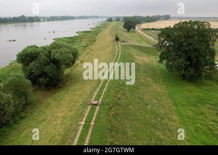 GESPEICHERT - 14. Juli 2021, Sachsen-Anhalt, Sandau: Blick auf den alten Deich Sandau-Süd an der Elbe (Luftaufnahme mit Drohne). Hier fand am Mittwoch der Spatenstich für das Deichschneiden statt. Die vergangenen Hochwasserereignisse in den Jahren 2002 und 2013 zeigten, dass der bestehende Deich zwischen Sandau und Havelberg dringend renoviert werden muss. Die Deichumsiedlung ist Teil des Nationalen Hochwasserschutzprogramms der Bundesrepublik Deutschland und des Programms "Mehr Raum für unsere Flüsse" in Sachsen-Anhalt. Durch den Umzug werden hier rund 124 Hektar Auen zurückgewinnen, verglichen mit etwa 60 Hektar Stockfoto