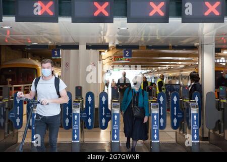 London, Großbritannien, 14. Juli 2021: Gesichtsmasken sind derzeit für Network Rail obligatorisch, sind aber ab dem 19. Juli, dem sogenannten Freedom Day, optional. Wenn Passagiere Züge verlassen, die am Londoner Terminal von Charing Cross ankommen, tragen die meisten Masken, aber ab nächster Woche werden sie nur noch gefragt, wenn die Wagen voll sind. Anna Watson/Alamy Live News Stockfoto