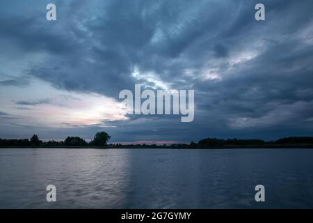 Dunkler Abend Wolken Landschaft über dem See, Frühlingsblick Stockfoto