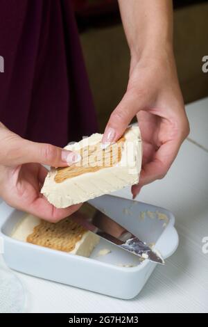 Frau schneidet hausgemachtes Eis. Kekse und Creme. Nahaufnahme. Stockfoto