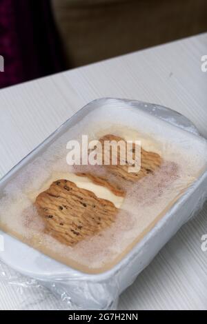 Hausgemachtes Eis. Kekse und Creme. Verpackt in Plastikfolie. Nahaufnahme. Stockfoto