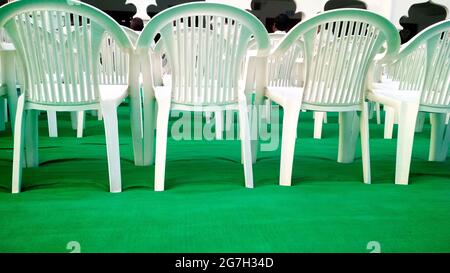 Reihen leerer weißer Stühle warten in indien auf das Publikum Stockfoto