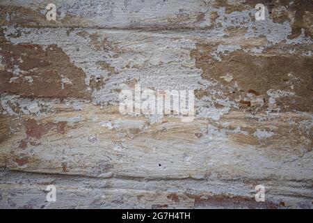 Weiß gestrichene alte Backsteinmauer mit roten rissigen Ziegeln. Hintergrund, Oberfläche, Textur für Design. Stockfoto
