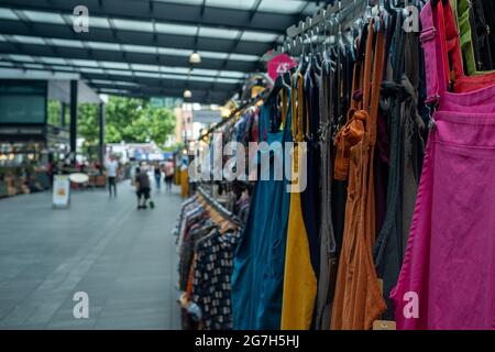 London - Juli 2021: Bunte Kleidung zum Verkauf auf dem Spitalfields-Markt in East London Stockfoto