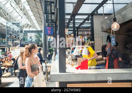 London - Juli 2021: Imbissstände auf dem Spitalfields Market. Ein beliebter Markt mit Lebensmitteln, Bars, Kunst und Kunsthandwerk Stockfoto
