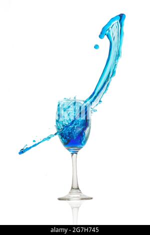 Weinglas auf weißem Hintergrund mit einem blauen Wasserspritzer. Stockfoto