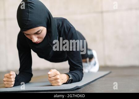 Junge muslimische Frau im Hijab macht beim Training in Innenräumen Sport Stockfoto