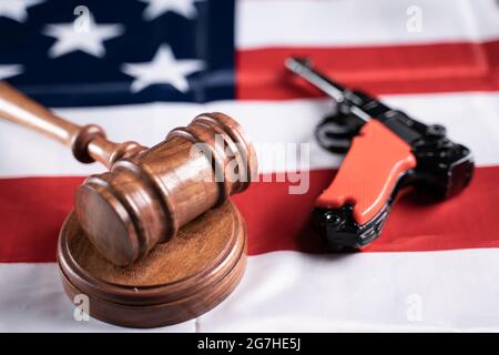 Konzept zur Darstellung der US- oder amerikanischen Waffengesetze mit Judge Gavel und Vintage Pistol auf amerikanischer Flagge Stockfoto