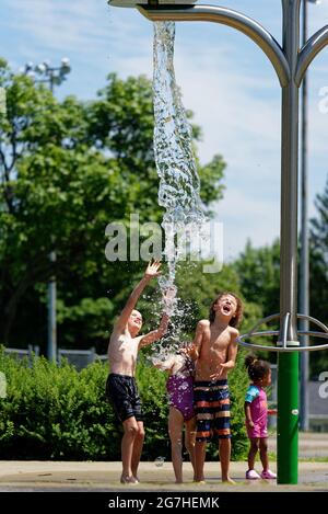 Drei Kinder spielen in Quebec City, Kanada, Wasserspiele und Springbrunnen Stockfoto