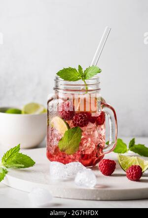 Erfrischender Mojito-Cocktail im kalten Sommer mit Himbeeren, Minze und Limette in einem Glas-Einmachglas. Speicherplatz kopieren. Stockfoto