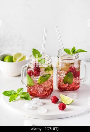 Zwei Glas Maurer Gläser kalten Sommer erfrischenden Mojito Cocktail mit Himbeeren, Minze und Limette. Selektiver Fokus. Speicherplatz kopieren. Stockfoto