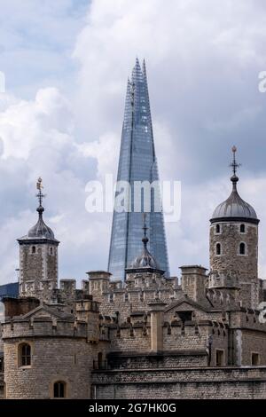 Der Shard, der durch die Türme des Tower of London am Tower Hill gesehen wird, zeigt einen unverwechselbaren Kontrast zwischen einem mittelalterlichen und einem modernen Wahrzeichen Stockfoto