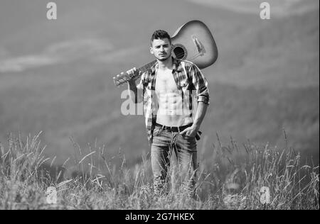 Mann mit Gitarre, der auf dem Berg läuft. Die beste Art, aus der Stadt zu entkommen. Guy Wanderer genießen Natur pur. Erkunden Sie die Natur. Die Schönheit der Natur. Frisch Stockfoto