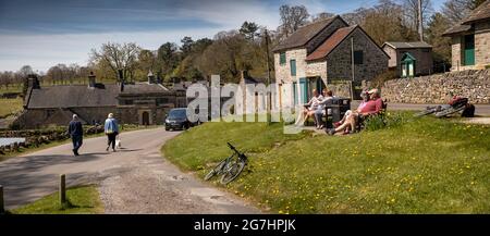 Großbritannien, England, Derbyshire, Tissington, The Green, Radfahrer ruhen auf Bänken am Dorfteich Stockfoto