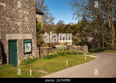 Großbritannien, England, Derbyshire, Tissington, The Green, Village Notice Board und Herbert’s Hollow on Chapel Lane Stockfoto