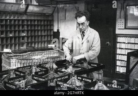 1940er Jahre, historisch, ein männlicher GPO-Arbeiter in einer Sortierstelle, mit Postsäcken, London, England, Großbritannien. Stockfoto