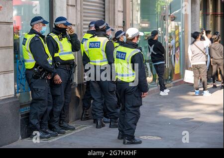 LONDON - 29. MAI 2021: Eine Gruppe britischer Polizeibeamter mit PSA-Gesichtsmasken auf einer Londoner Straße Stockfoto