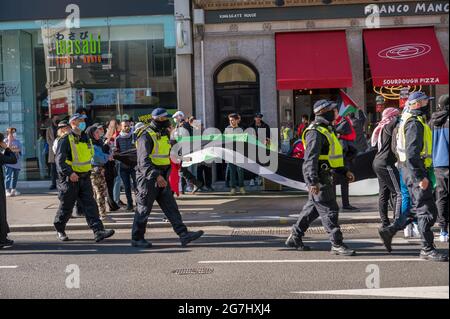 LONDON - 29. MAI 2021: Britische Polizisten gehen bei einer Protestkundgebung für die Freiheit für Palästina in London mit Demonstranten zusammen Stockfoto