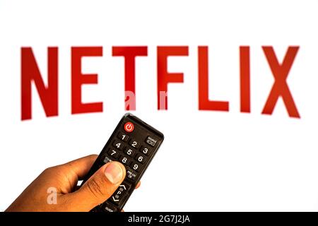 Spanien. Juli 2021. In dieser Abbildung sehen Sie eine Nahaufnahme einer Hand, die eine TV-Fernbedienung hält, die vor dem Netflix-Logo angezeigt wird. (Foto von Thiago Prudencio/SOPA Images/Sipa USA) Quelle: SIPA USA/Alamy Live News Stockfoto